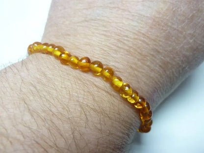 Bracelet ambre naturel perles rondes jaune translucide porté au poignet bienfaits apaisants et énergétiques