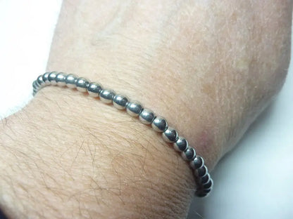Bracelet en hématite naturelle perles rondes qualité AAA sur poignet, bijou de lithothérapie protecteur et équilibrant