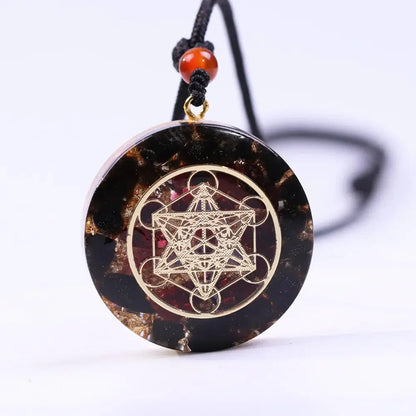 Pendentif Orgonite Cube de Métatron en obsidienne et grenat avec géométrie sacrée, cordon ajustable, protection énergétique et élévation vibratoire.
