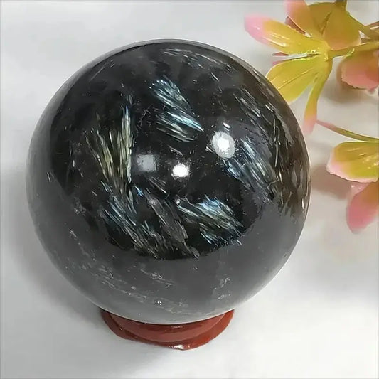 Sphère en Astrophyllite naturelle polie avec éclats métalliques bleutés, pierre de transformation et éclairage intérieur spirituel.